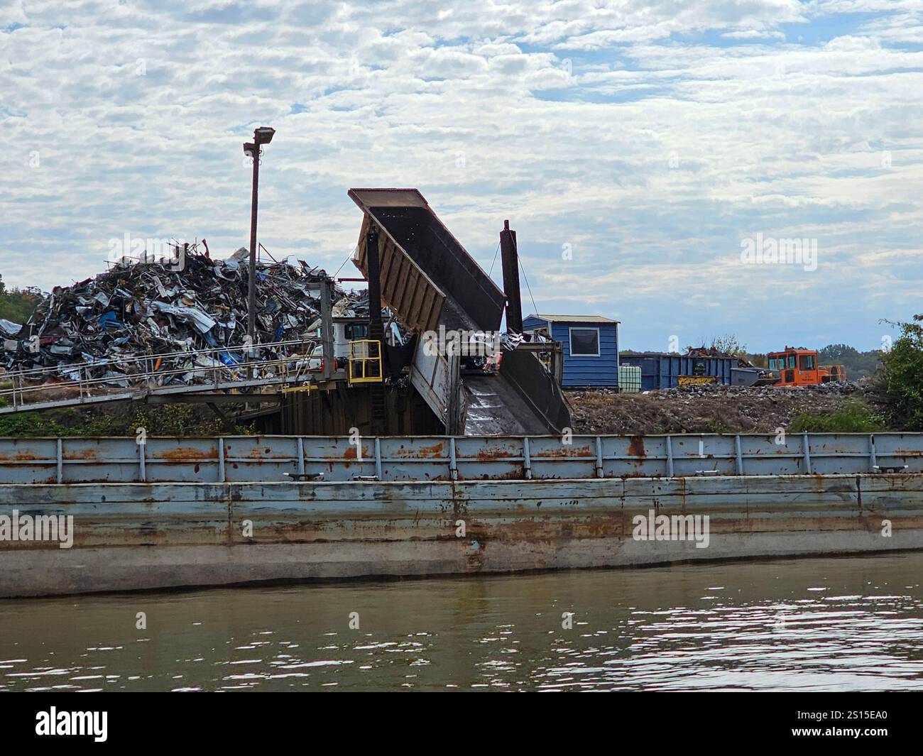 Metals for recycling are dumped onto a barge on the Tennessee River in Chattanooga, Tennessee - Smartphone Captured Stock Image