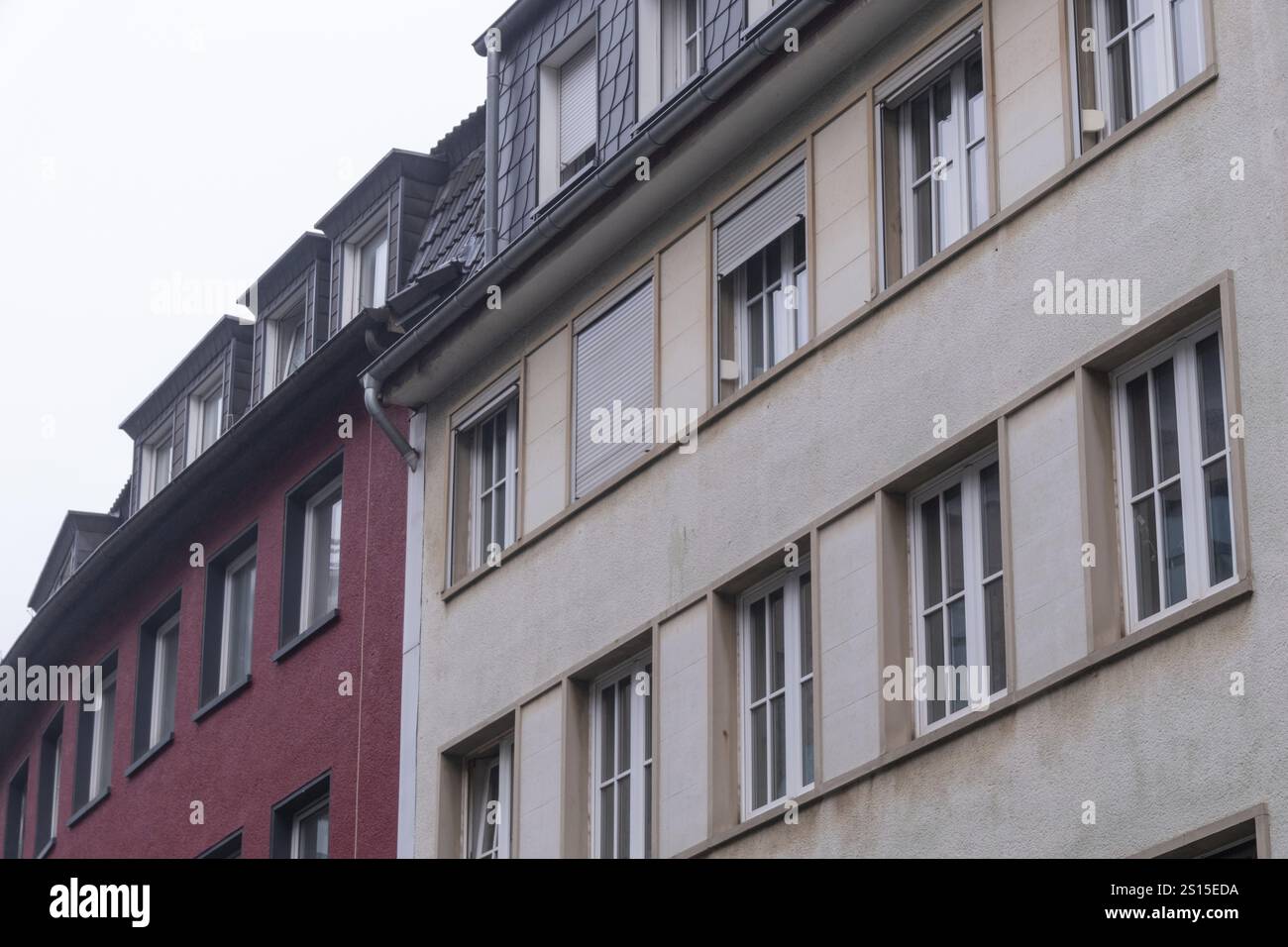 Two residential buildings standing side by side, showcasing contrasting ...