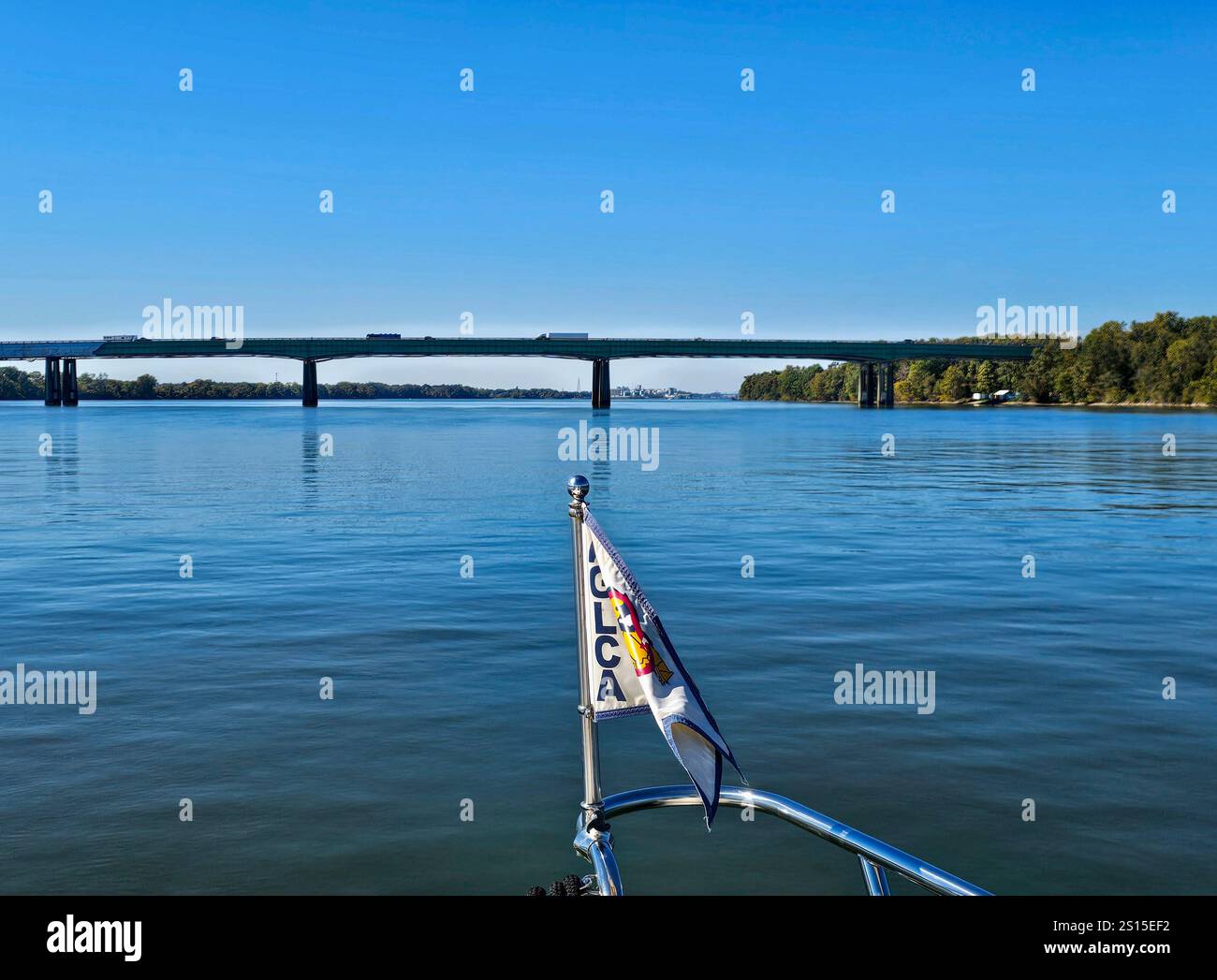 Interstate 65 bridge across the Tennessee River between Priceville and Mooresville, Alabama. A boat flying the Americas Great Loop flag approaches the - Smartphone Captured Stock Image