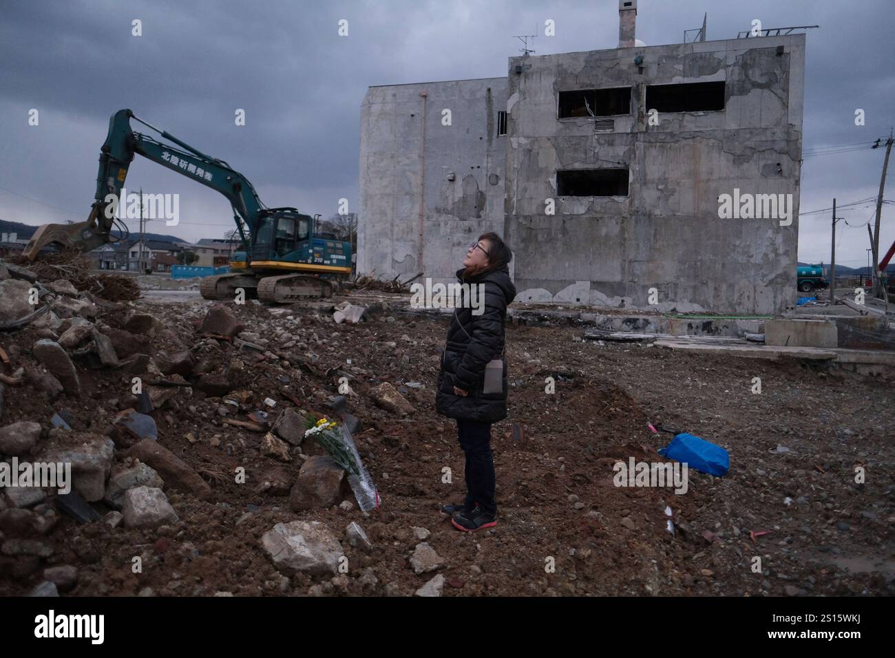 A woman offers flowers to mourn a relative who died in the 2025 Noto