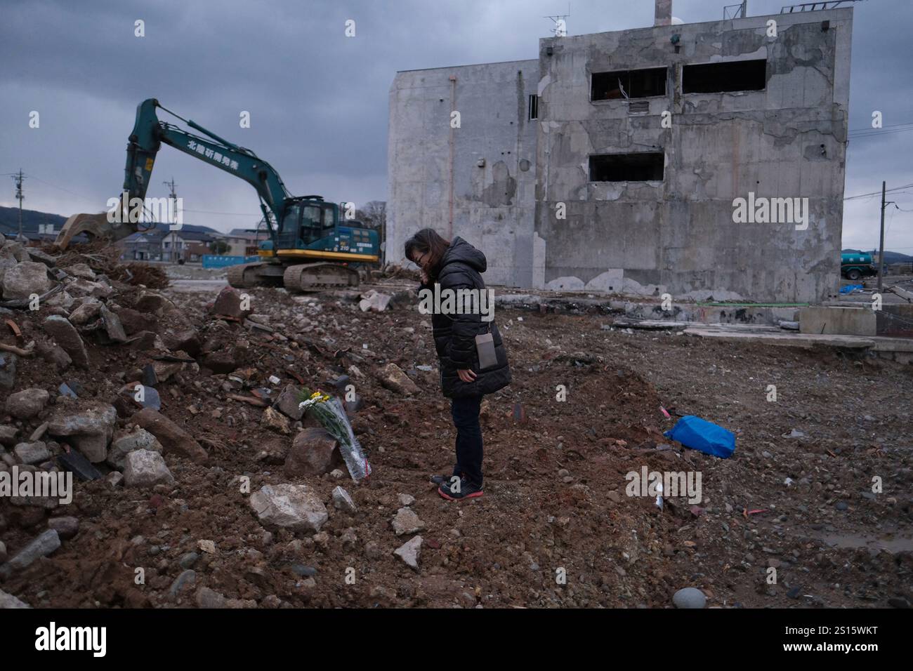 A woman offers flowers to mourn a relative who died in the 2024 Noto