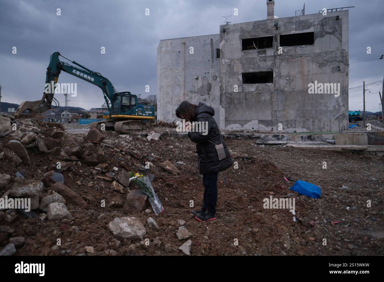 A woman offers flowers to mourn a relative who died in the 2024 Noto