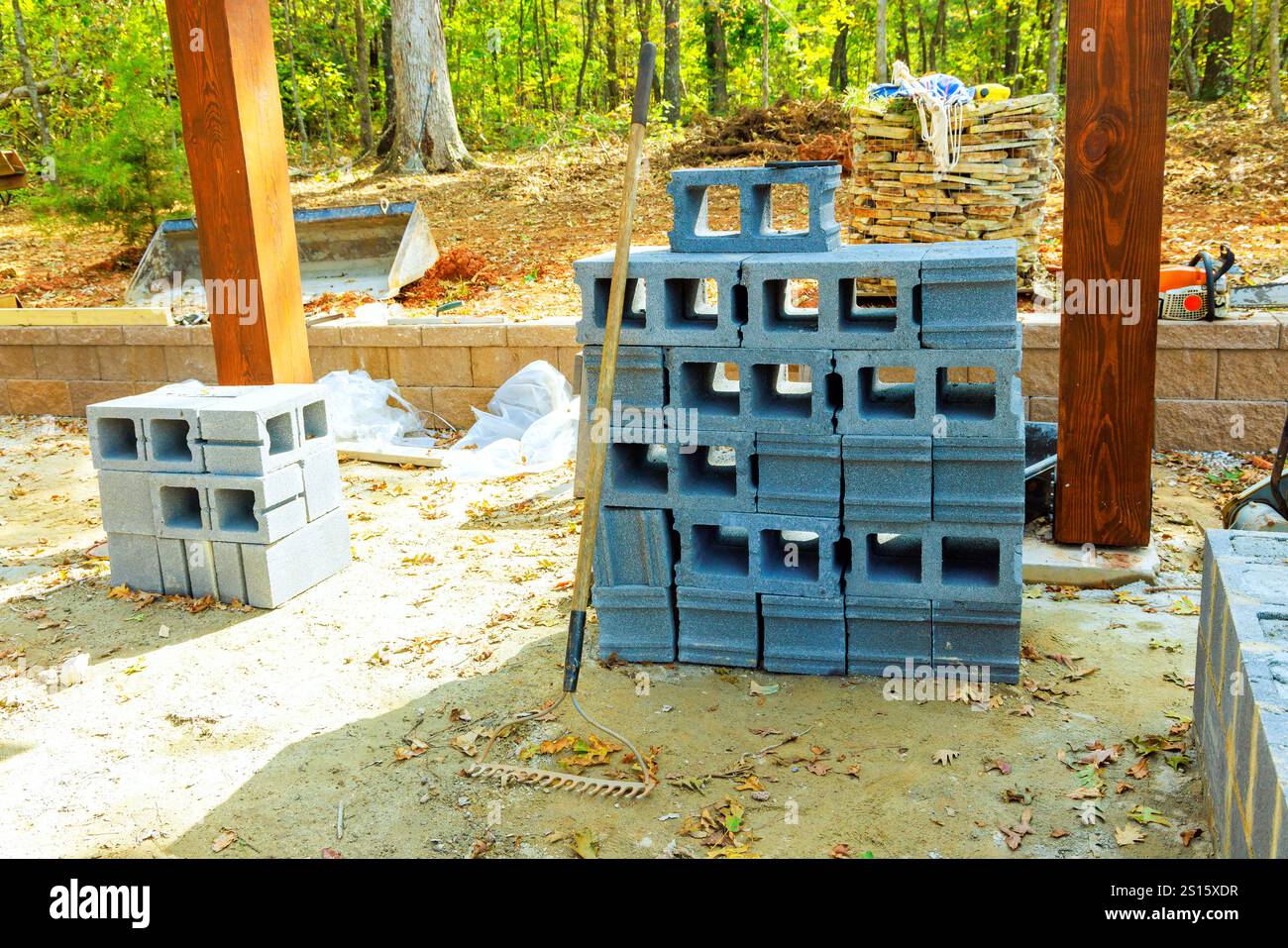 Concrete blocks are stacked at construction site amid trees ...