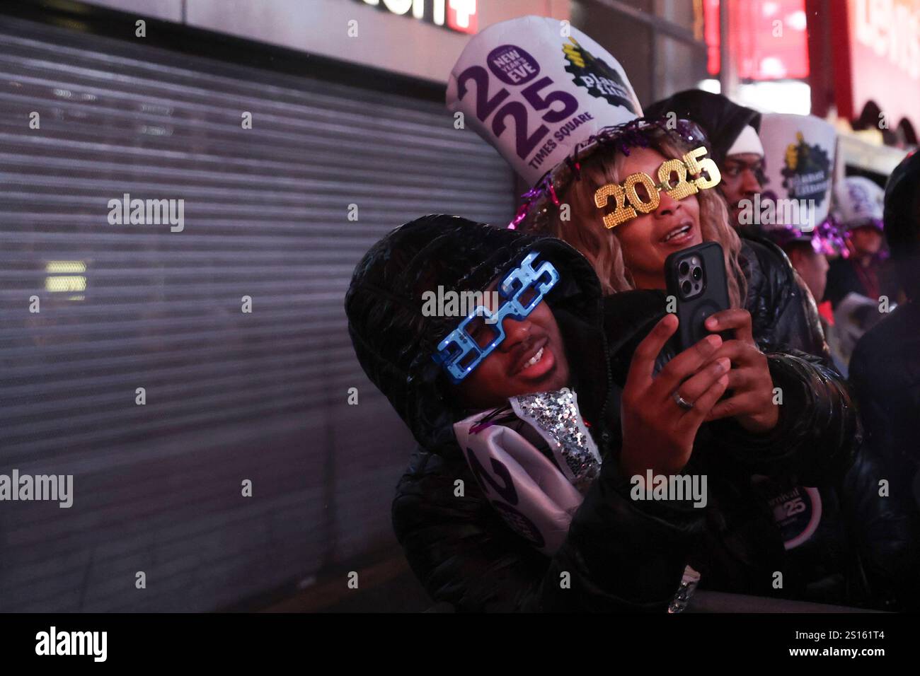 Revelers wear 2025 glasses during the annual New Year's Eve celebration