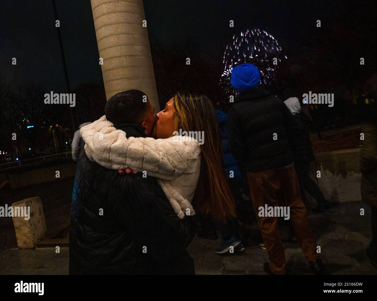 A couple shares a kiss just after midnight at a New Year's celebration