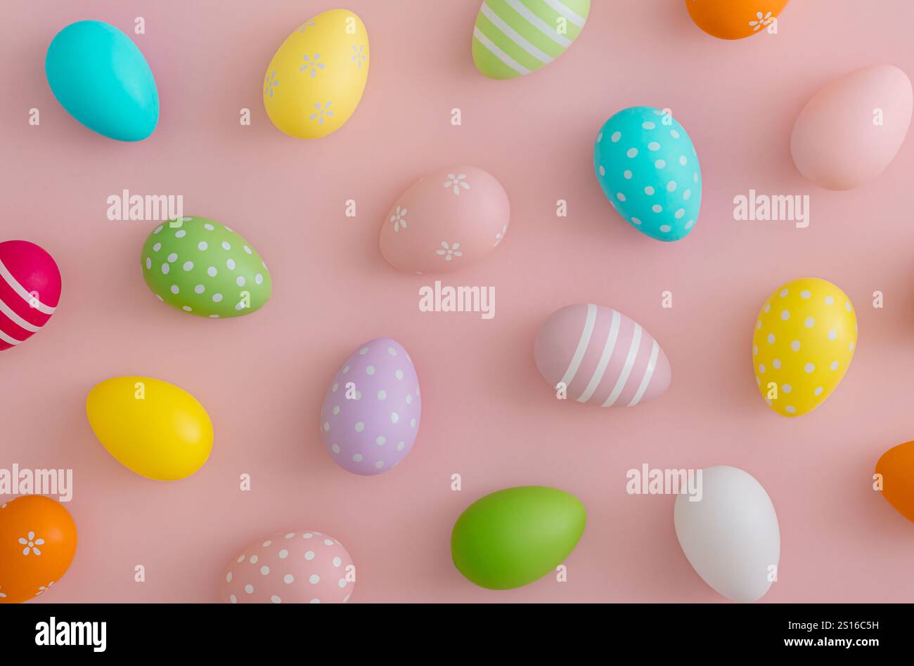 Creative Easter pattern composition made with colorful Easter eggs on light pastel pink background. Minimal Easter concept. Stock Photo