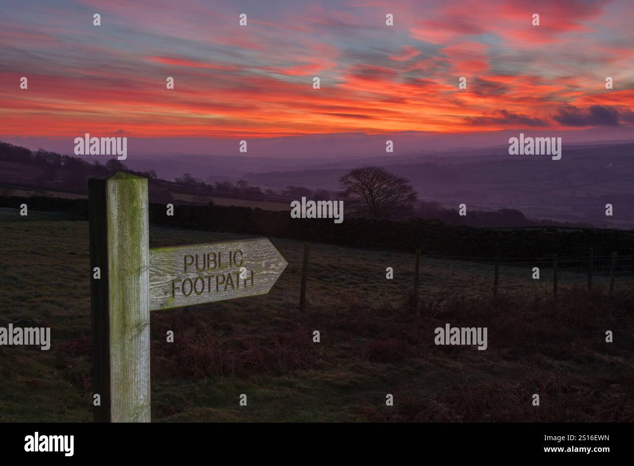 Public footpath sign shows the way in pre sunrise light looking over the Esk Valley in North York Moors national park - Stock Image