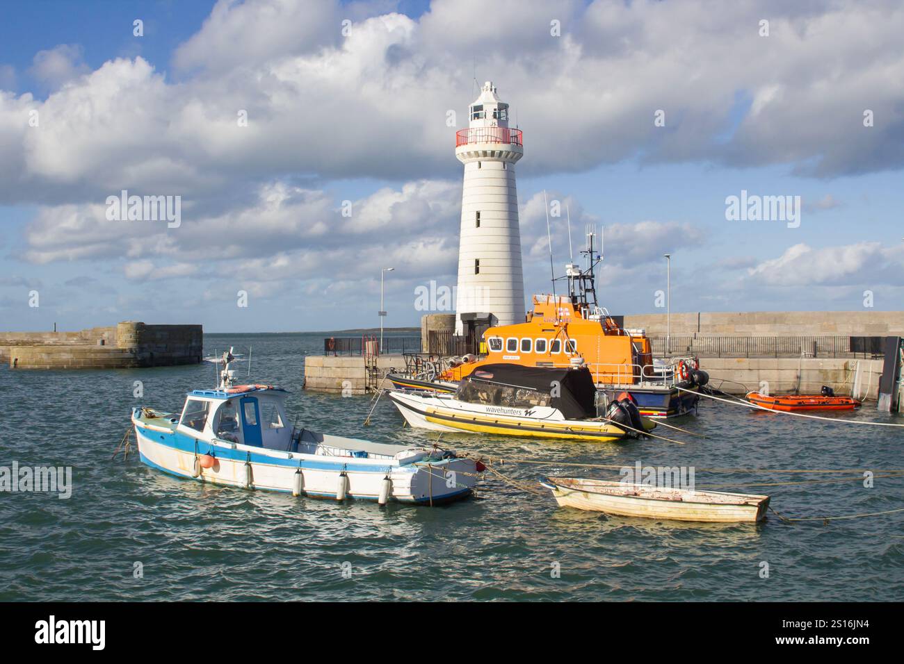 30 September 2022 Boats moored in Donaghadee Harbour, Northern Ireland in the soft sunlight of early autumn under the shadow of the local lighthouse. Stock Photo