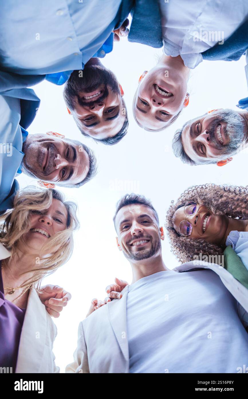 Diverse Team Smiling in a Circle, Bottom View.Vertical Stock Photo