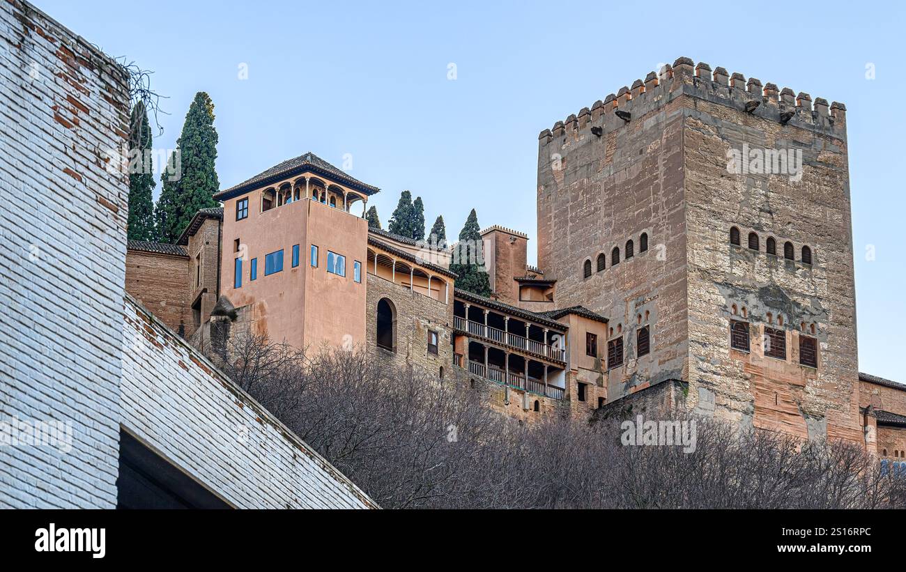Part of the Alhambra Palace and a fortified tower framed by an urban ...