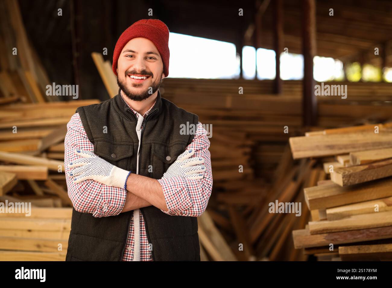 Portrait of young carpenter smiling at sawmill Stock Photo