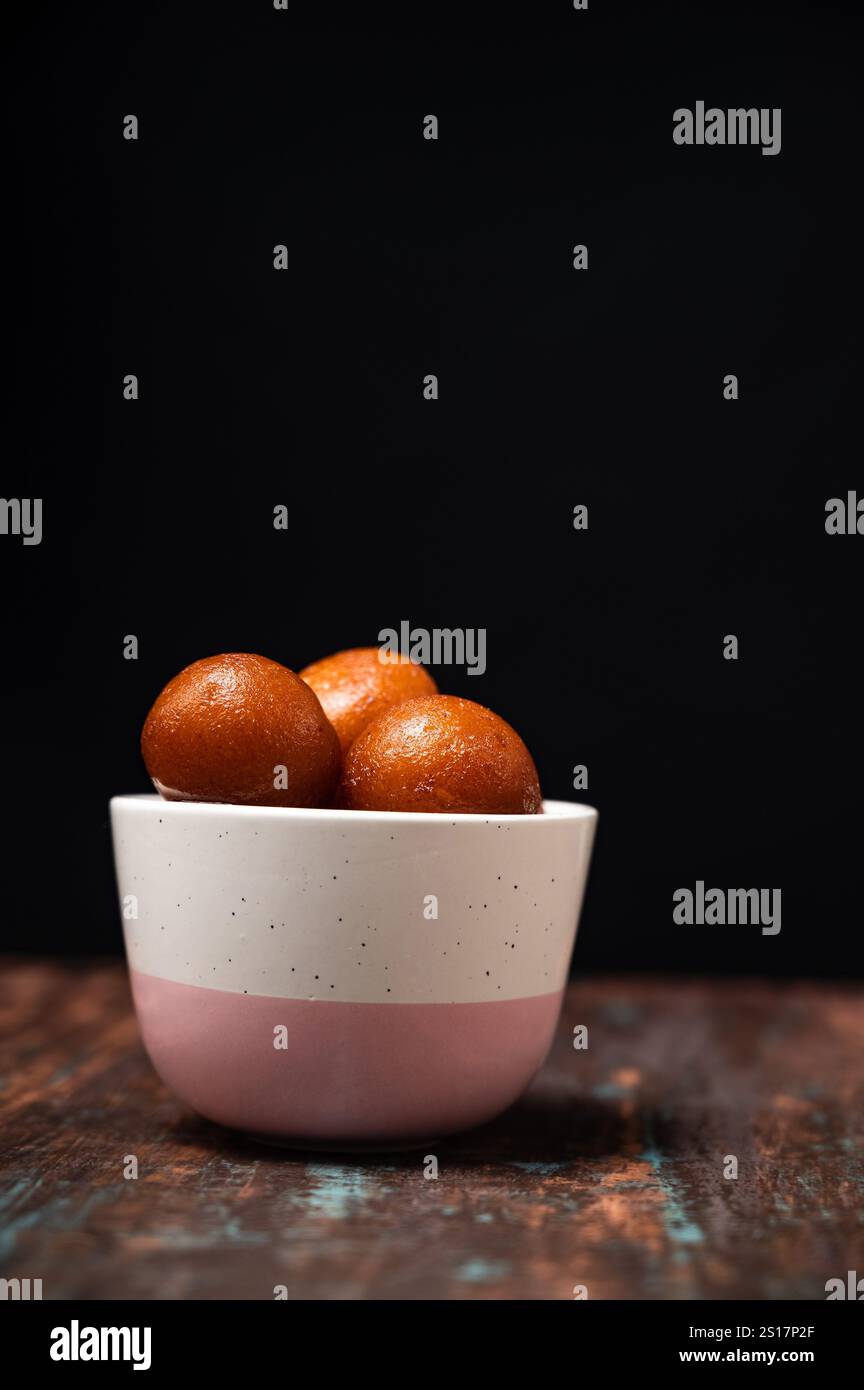 Gulab Jamun levitation on dark background. Traditional oriental food concept. Indian sweet snacks. Top view, flat lay, copy space Stock Photo