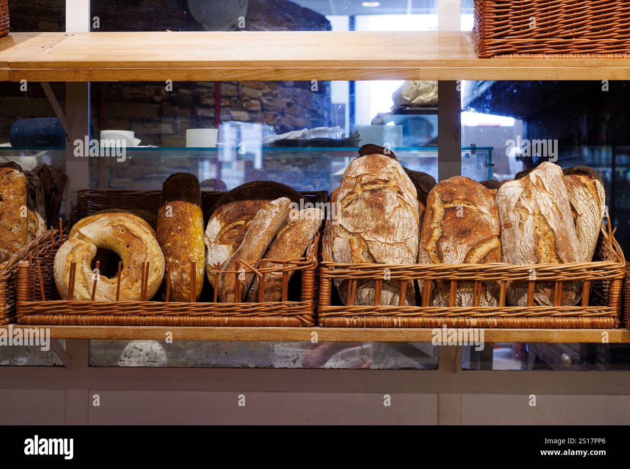 Freshly baked loaves of italian bread on wooden shelves in a bakery. Stock Photo