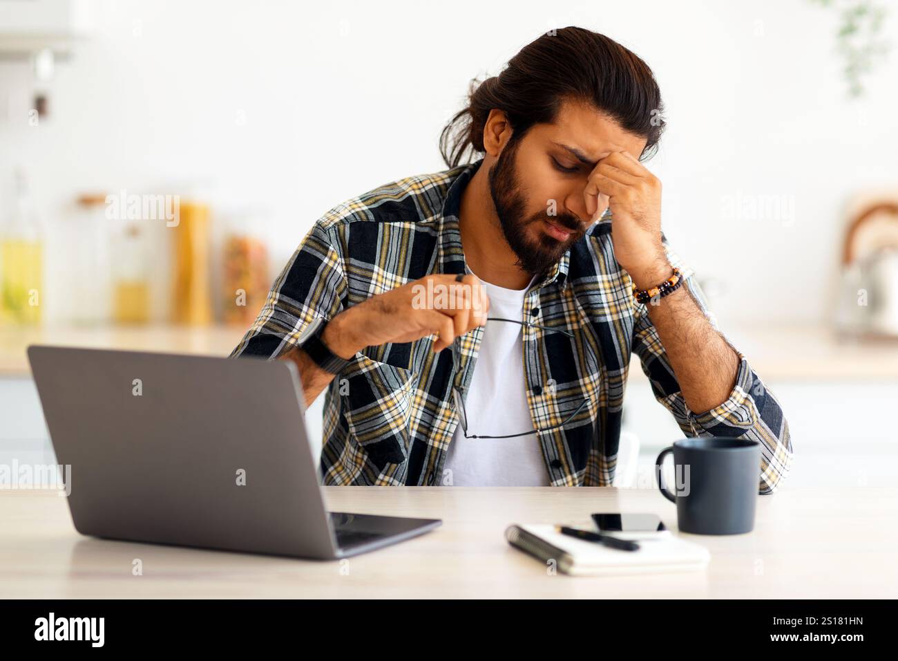 Tired middle-eastern man freelancer having difficulties at job Stock Photo