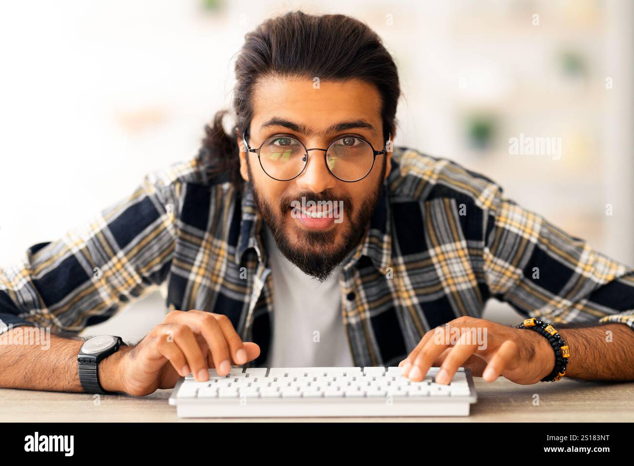 Young middle-eastern man programmer sitting at worktable Stock Photo