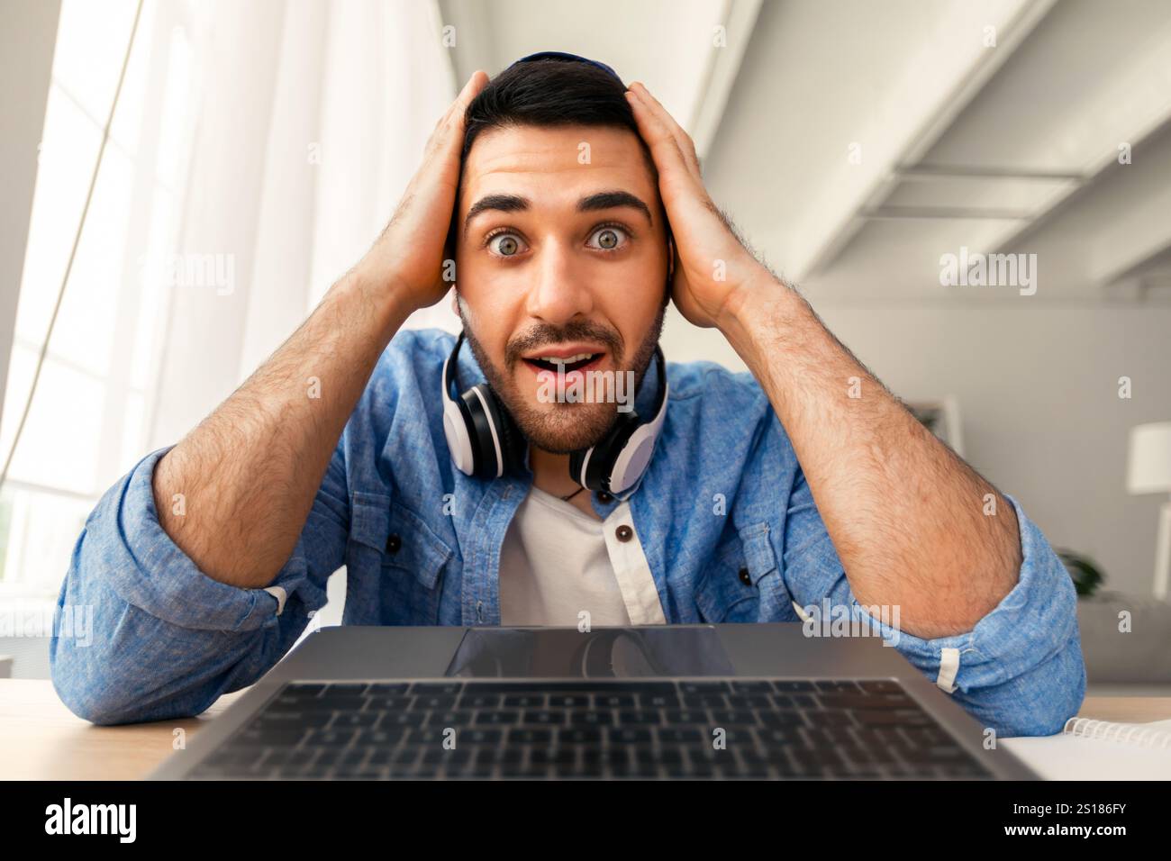 Surprised man having video call using laptop Stock Photo