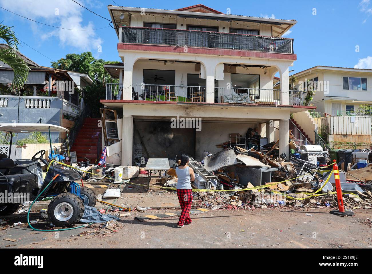 A woman stands in front of the home where a New Year's Eve fireworks