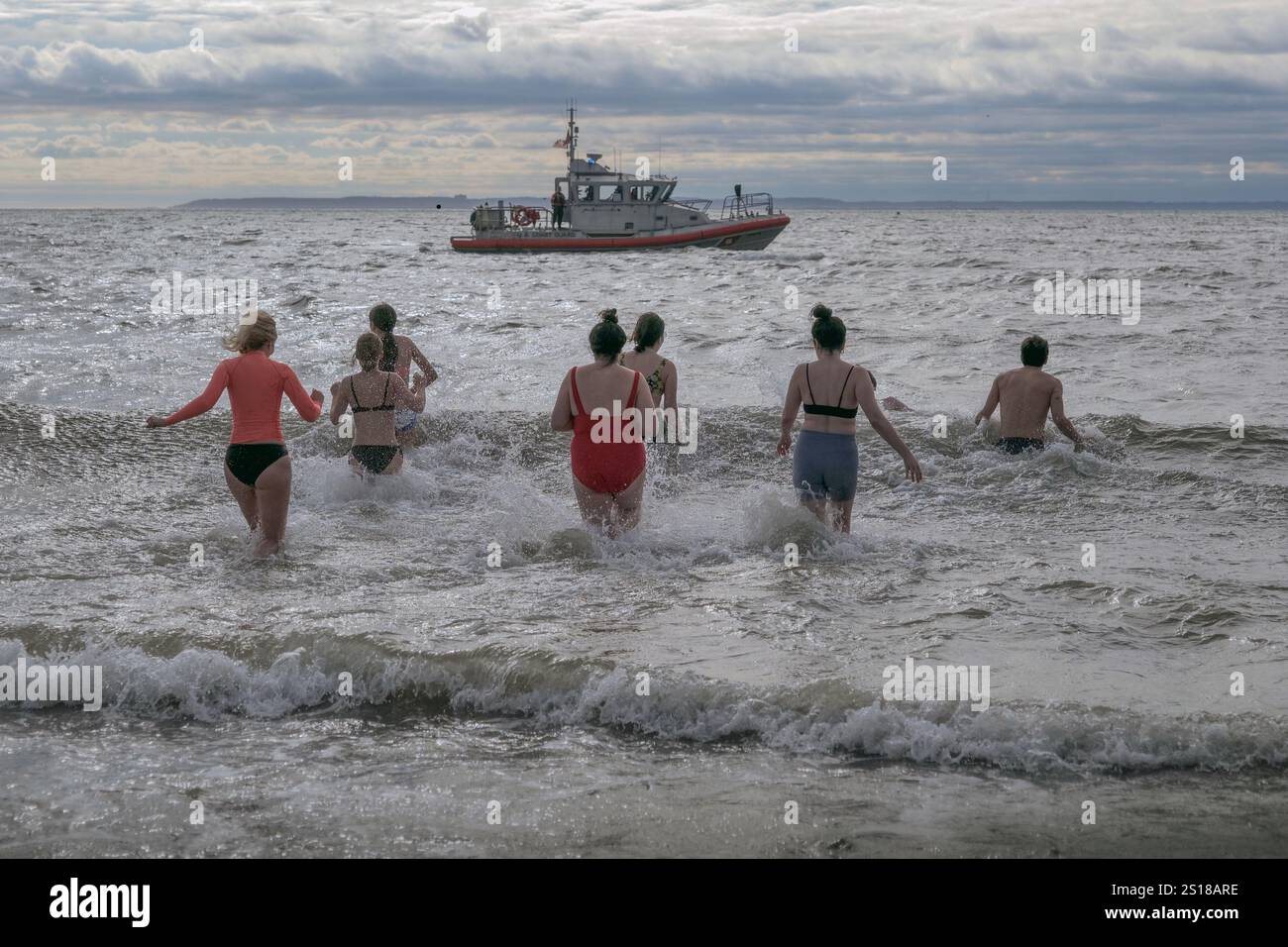 New York, New York, USA. 1st Jan, 2025. The annual Coney Island Polar Plunge took place under variable .cloudy skies and frigid Atlantic waters. The event by the Coney Island Polar bear Club since. 1903 drew thousands to the beach New Years day supporting non profits. (Credit Image: © Milo Hess/ZUMA Press Wire) EDITORIAL USAGE ONLY! Not for Commercial USAGE! Stock Photo