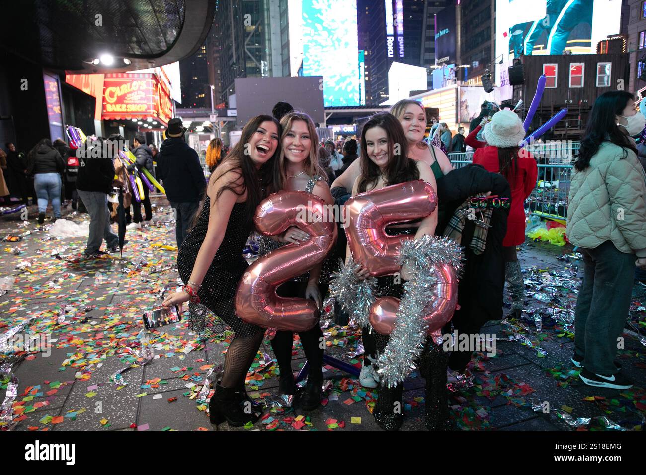 New York, USA.31th December 2024. Revelers holding balloons pose in