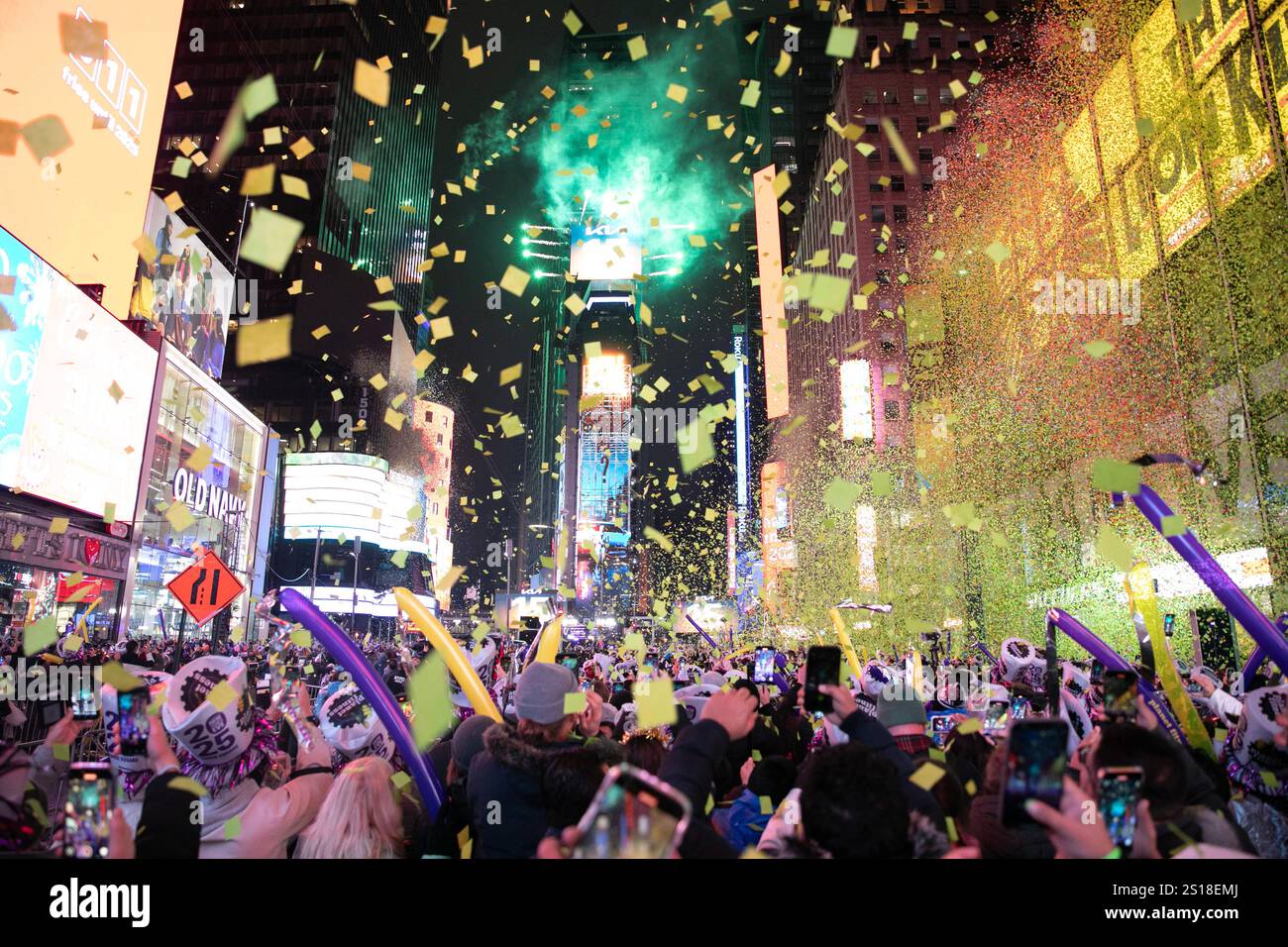 New York, USA.31th December 2024. Revelers watch and record as confetti
