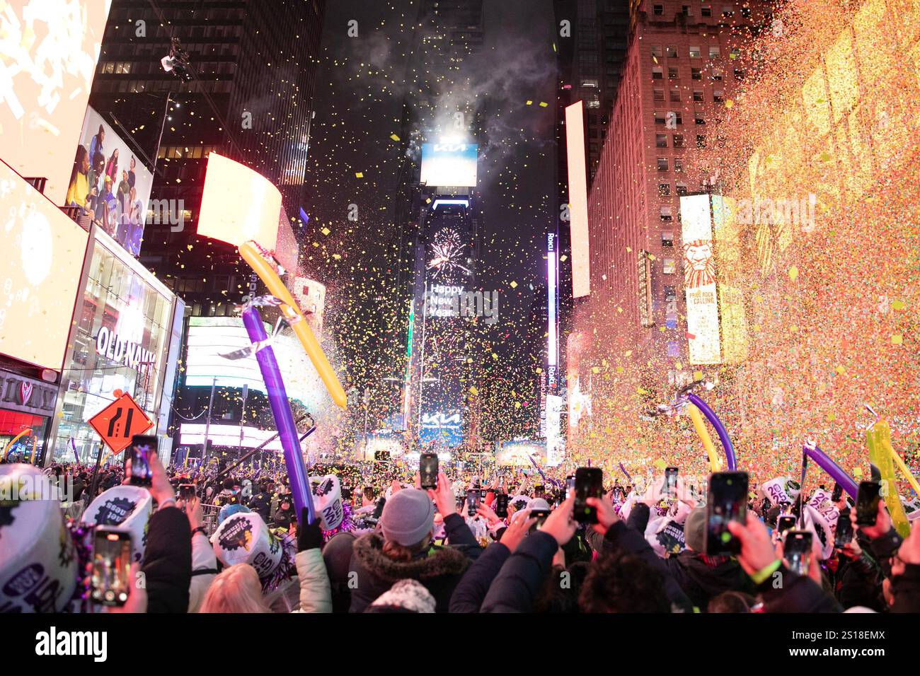 New York, USA.31th December 2024. Revelers watch and record as confetti