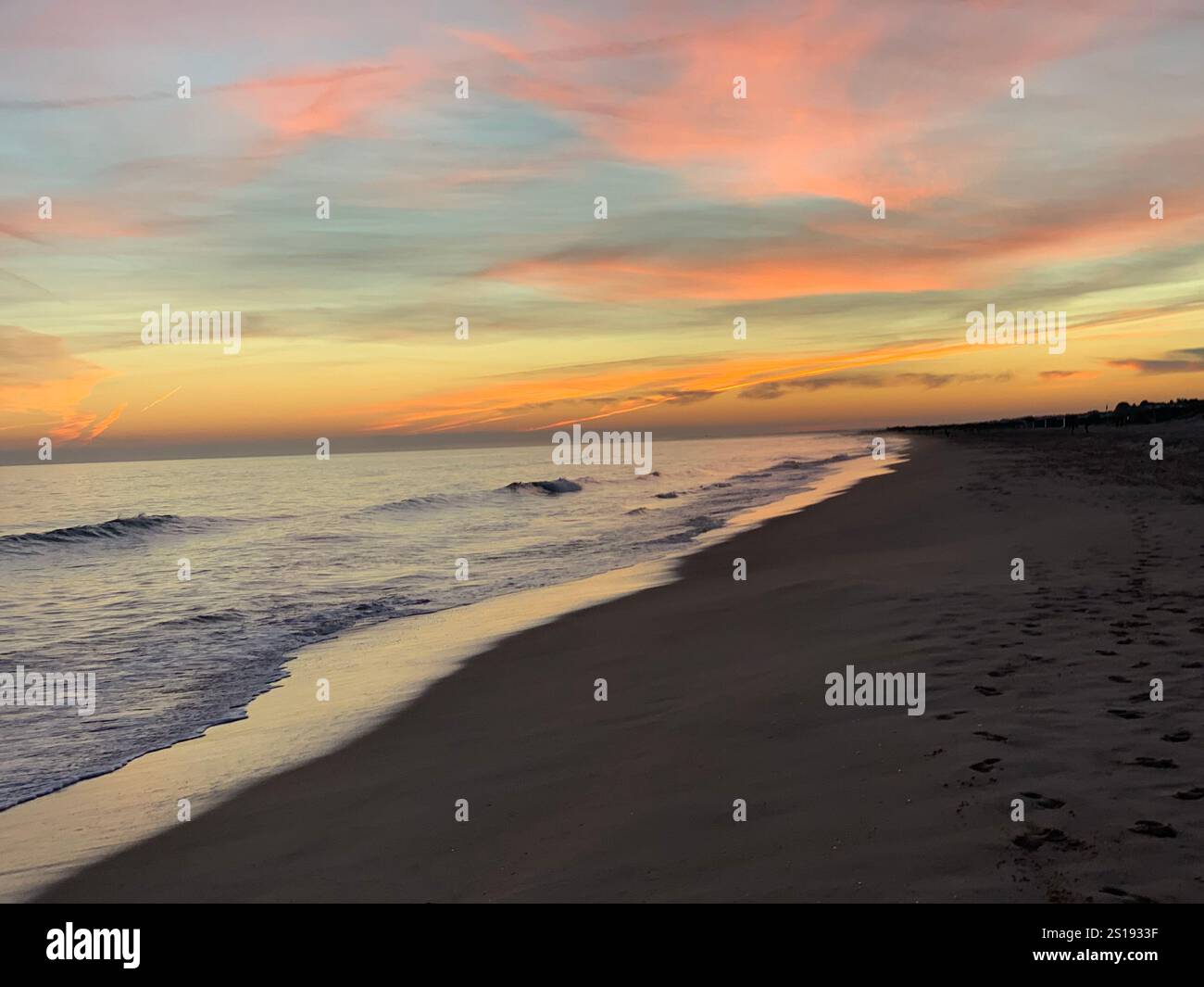 A serene view of the ocean at sunset, with soft hues of pink and orange painting the sky, creating a tranquil and peaceful atmosphere. - Smartphone Captured Stock Image