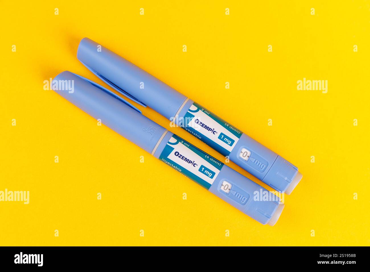 Top View of Ozempic 1 ml Medication Pens on Yellow Background in Barcelona, Spain, Highlighting Semaglutide and Injection Accessories Stock Photo