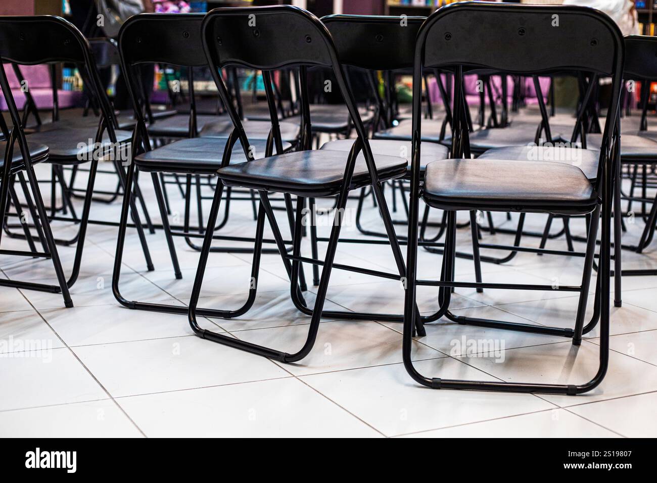 empty folding black chairs after conference in interior Stock Photo