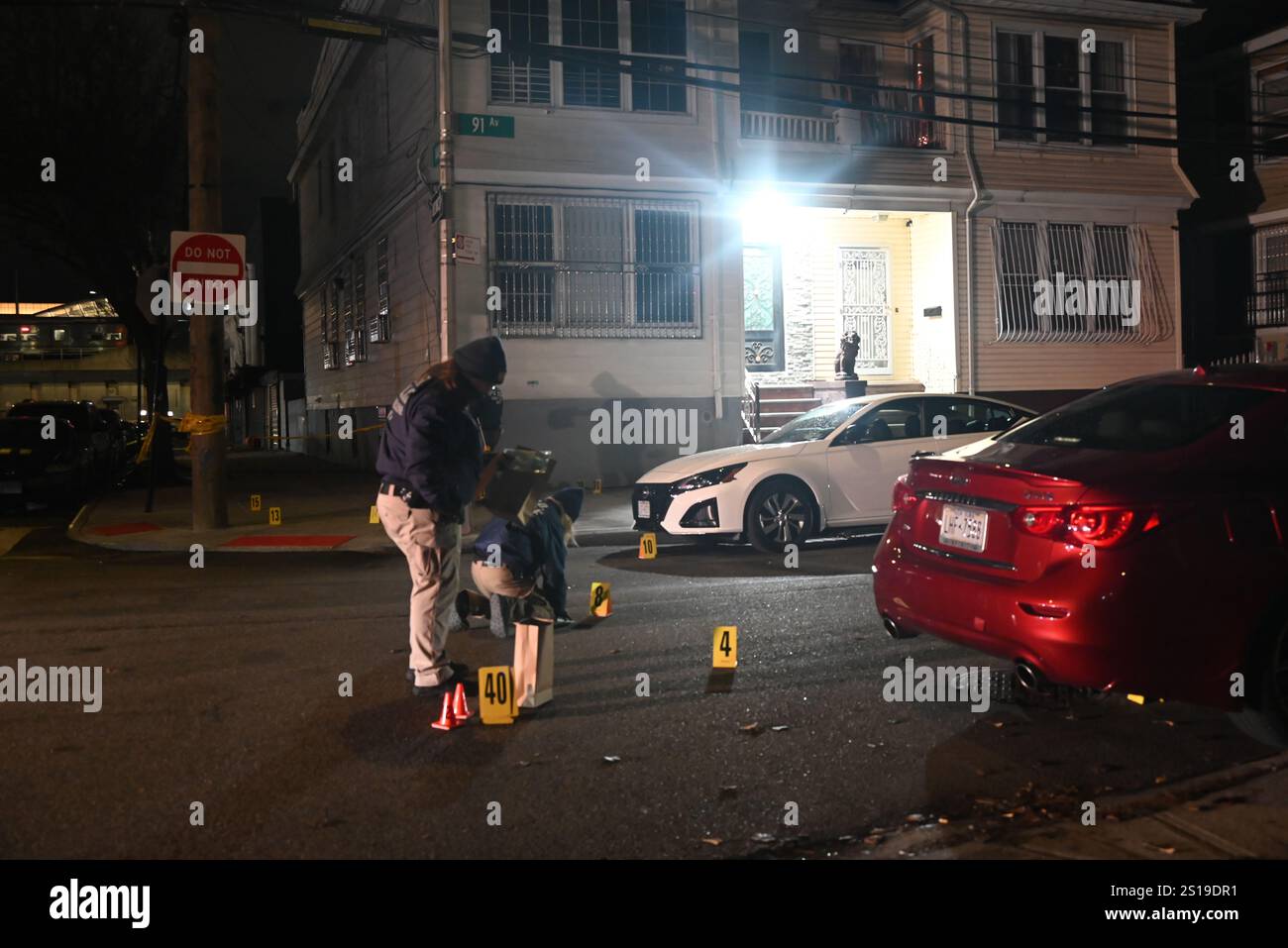 NYPD police officers place down evidence markers and collect shell ...