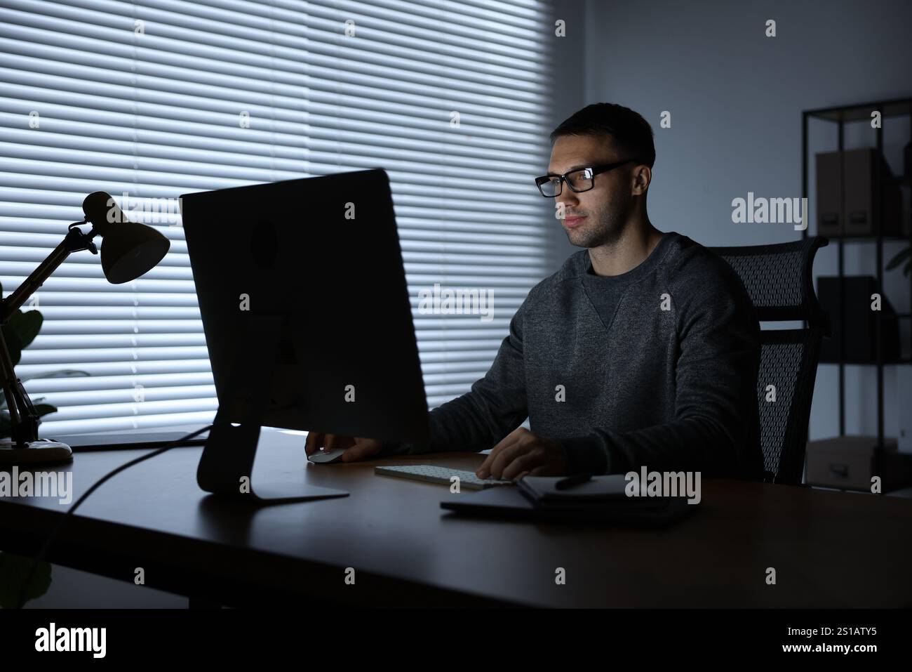 Programmer working on computer indoors at night Stock Photo