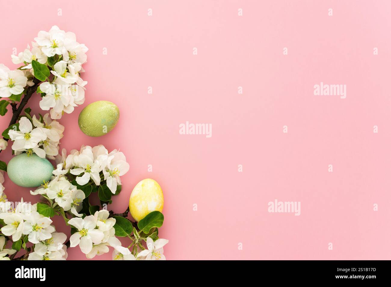 Spring Easter background, multi-colored Easter eggs and blooming apple tree branches on a pink background Stock Photo