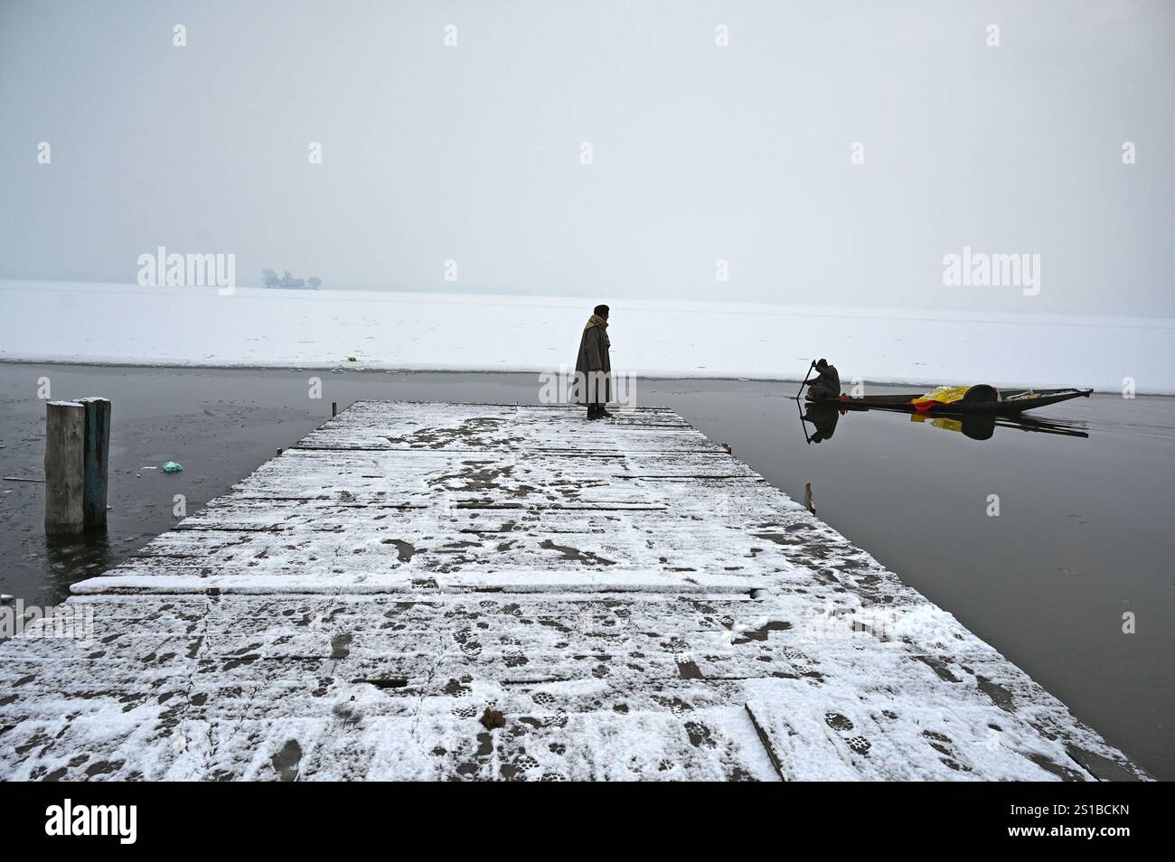 SRINAGAR, INDIA JANUARY 2 A man stands on a snow covered jetty of