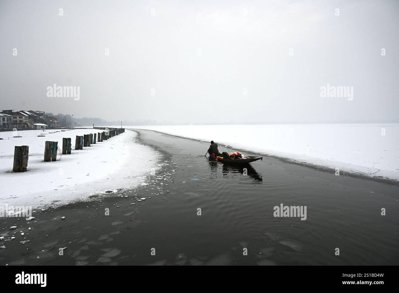 SRINAGAR, INDIA JANUARY 2 A man rows his boat through a frozen