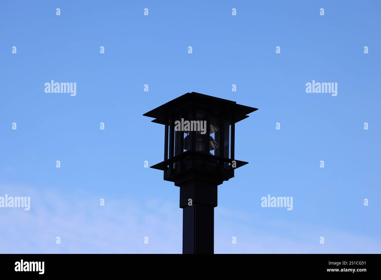 black iron outdoor light fixture against a deep blue sky Stock Photo