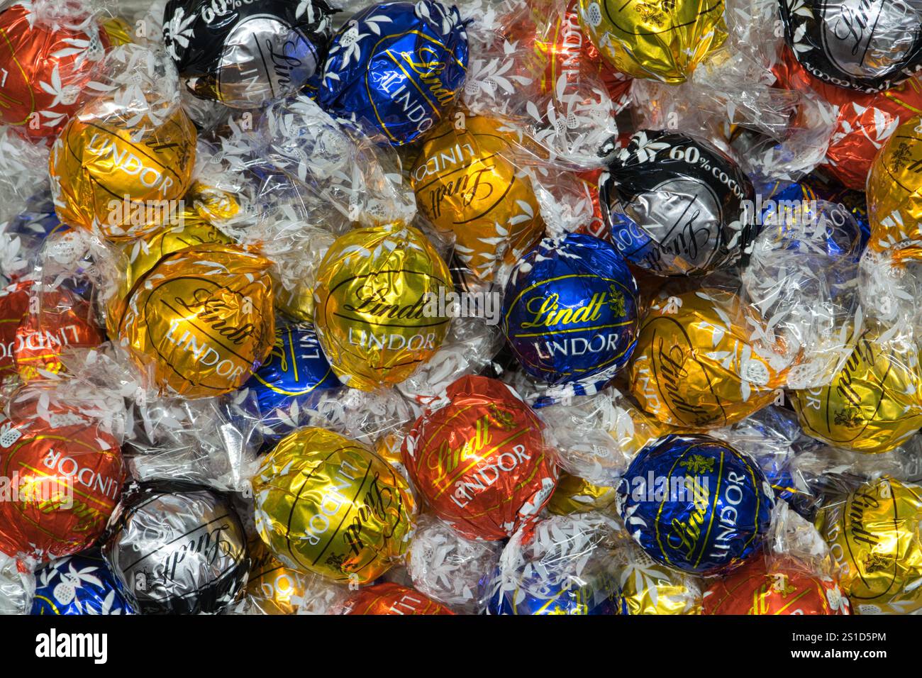 Houston, Texas USA 01-01-2025: Lindt Lindor chocolate truffles in wrappers scattered flat lay. Stock Photo