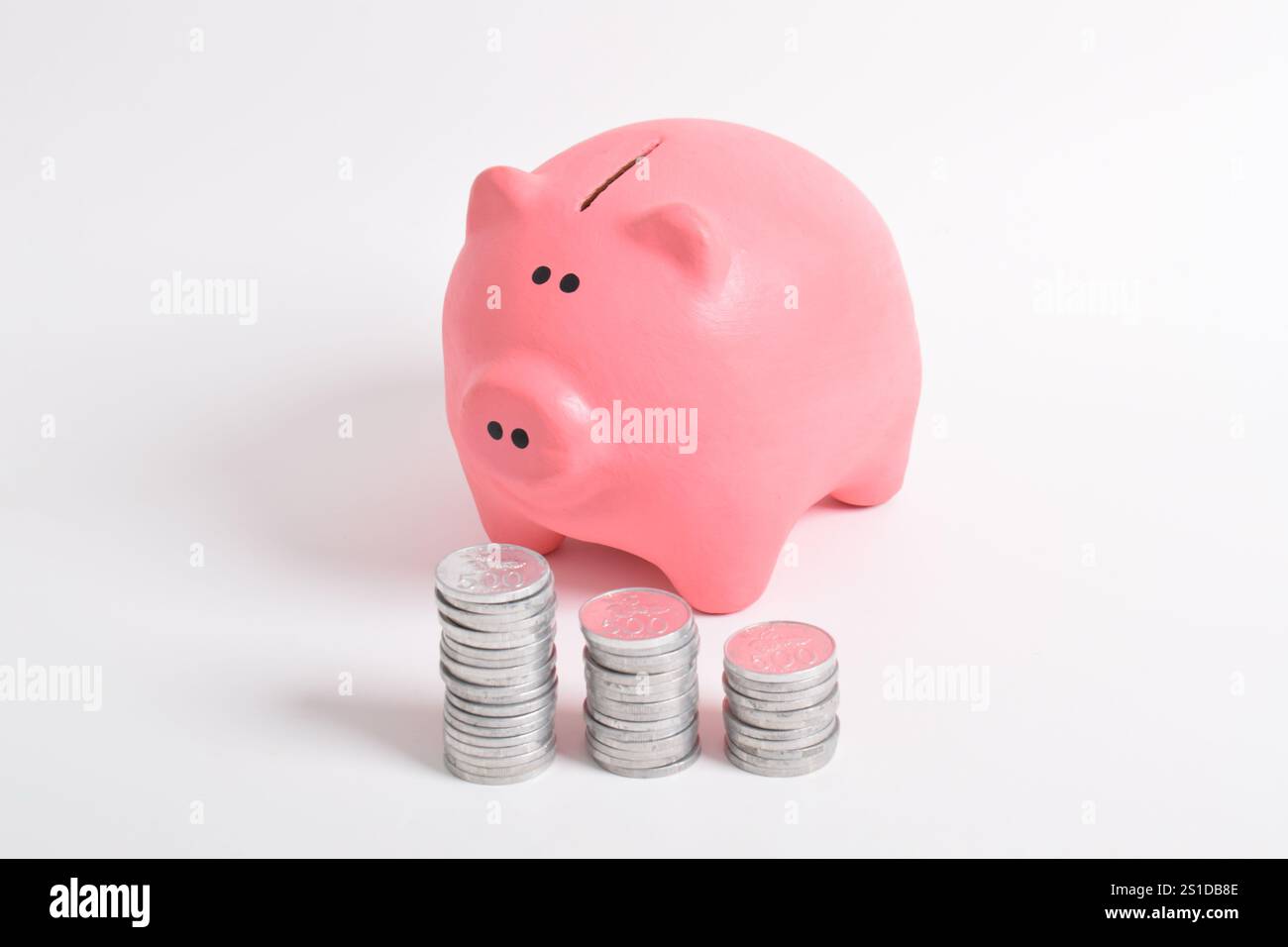 Pink piggy bank and stack of coins isolated on white background ...