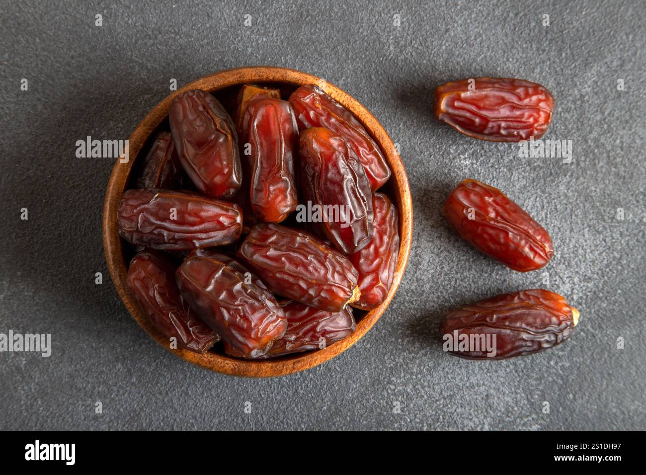 Large dates fruit in a wooden bowl, top view Stock Photo
