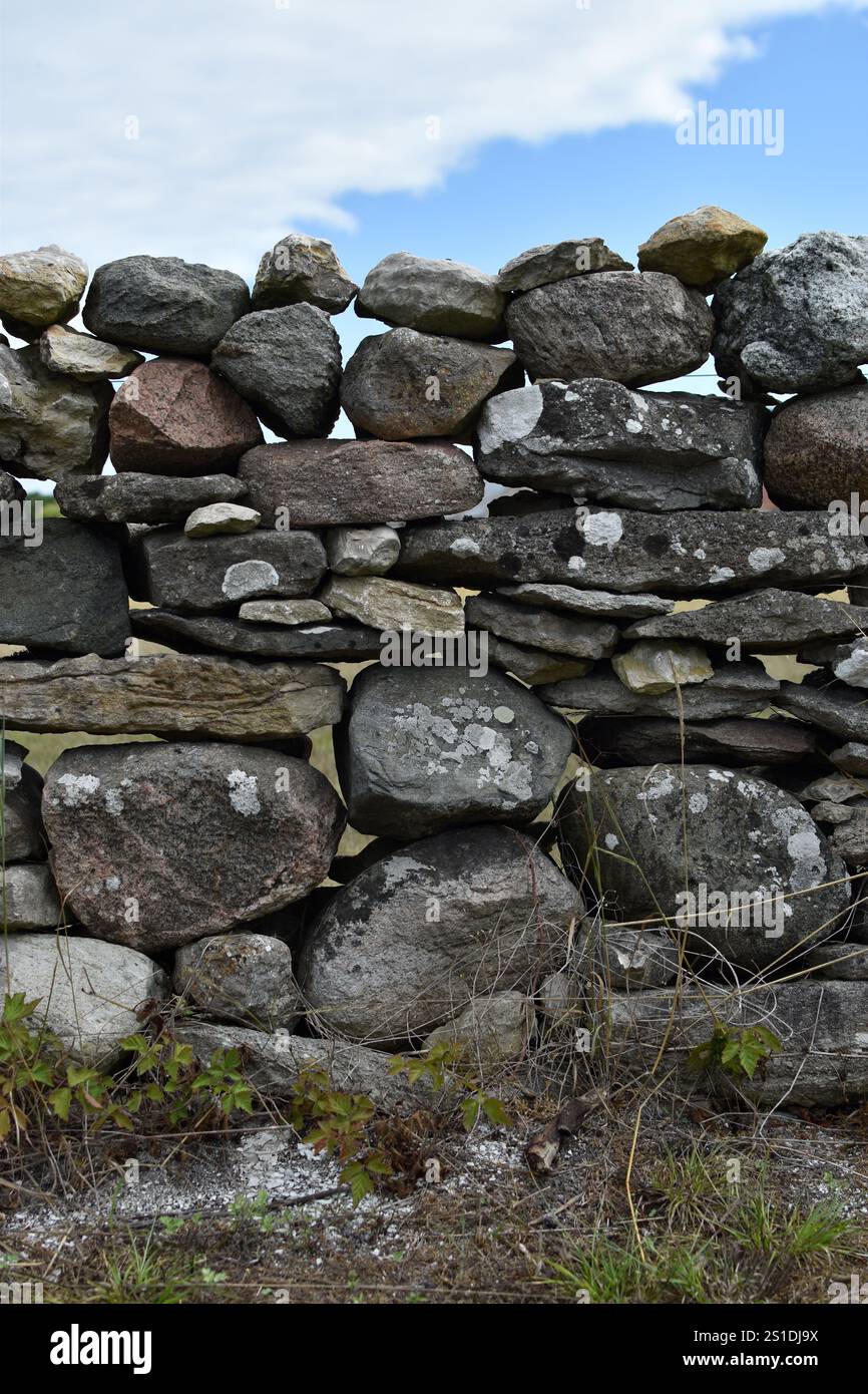 Rustic Strong Picture A rustic stone wall stands strong amidst green grass under a blu Stock ...