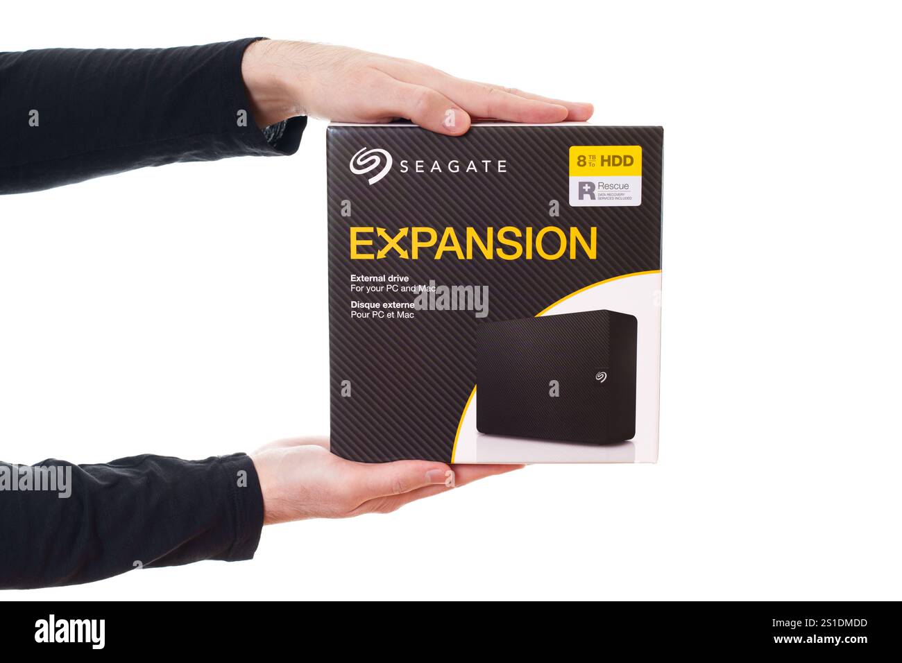 Kyiv, Ukraine - October 23, 2024: Hands holding the Seagate Expansion 8TB external hard drive packaging, showcasing product name and features on a whi Stock Photo