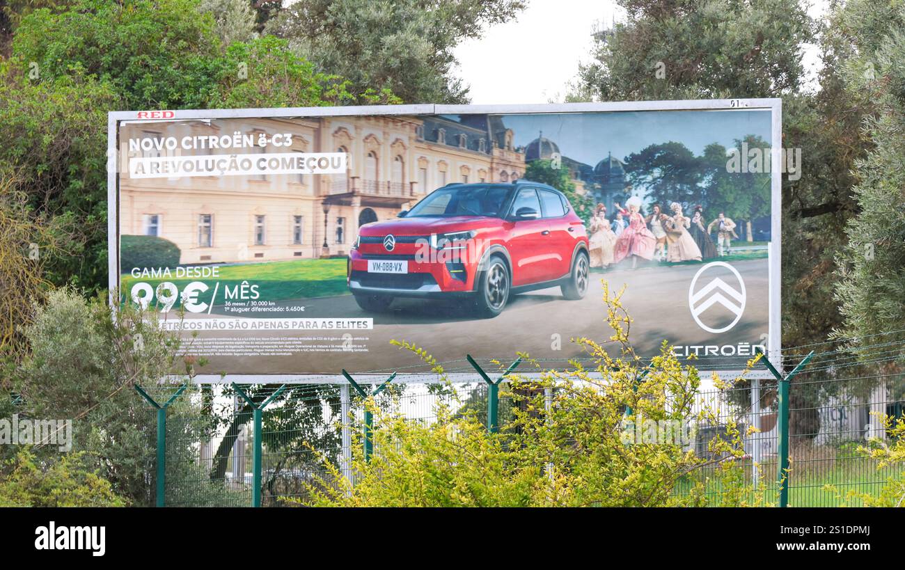 Large billboard displays an advertisement for the new citroen e c3 electric car, featuring the vehicle and people in period costumes against a backdro Stock Photo