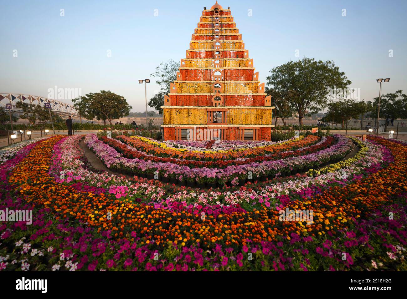 A man walks past a sculpture of a temple made by flowers at a Flower