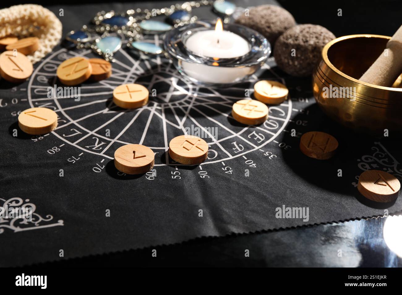 Wooden runes and burning candle on divination mat, closeup Stock Photo ...