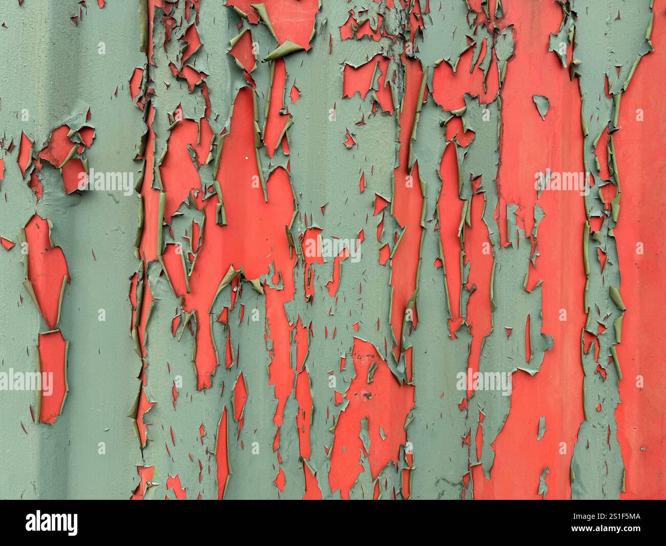 Peeling green paint on corrugated iron with red paint underneath. - Smartphone Captured Stock Image