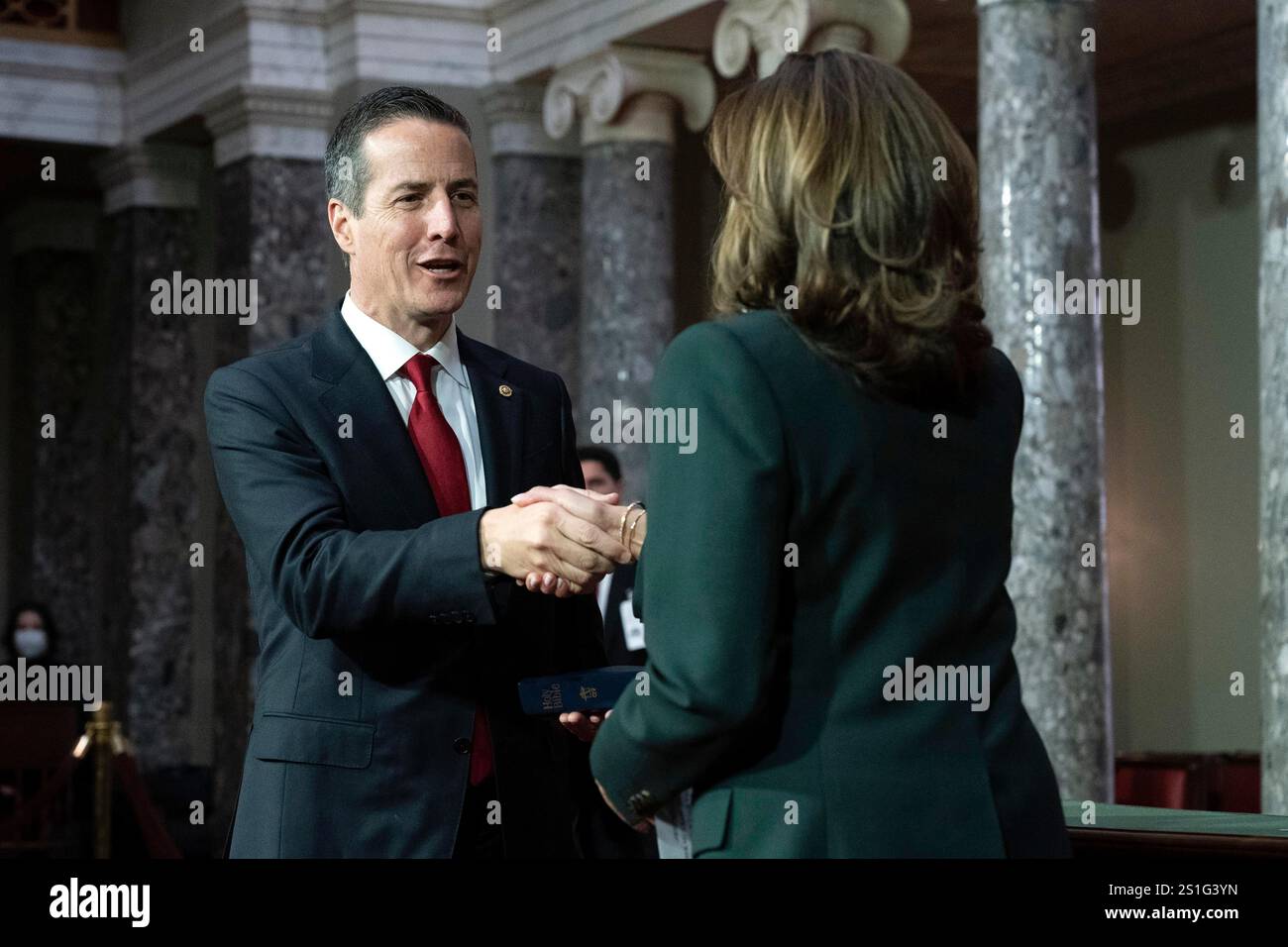 Vice President Kamala Harris, right, shake hands with Sen. Bernie