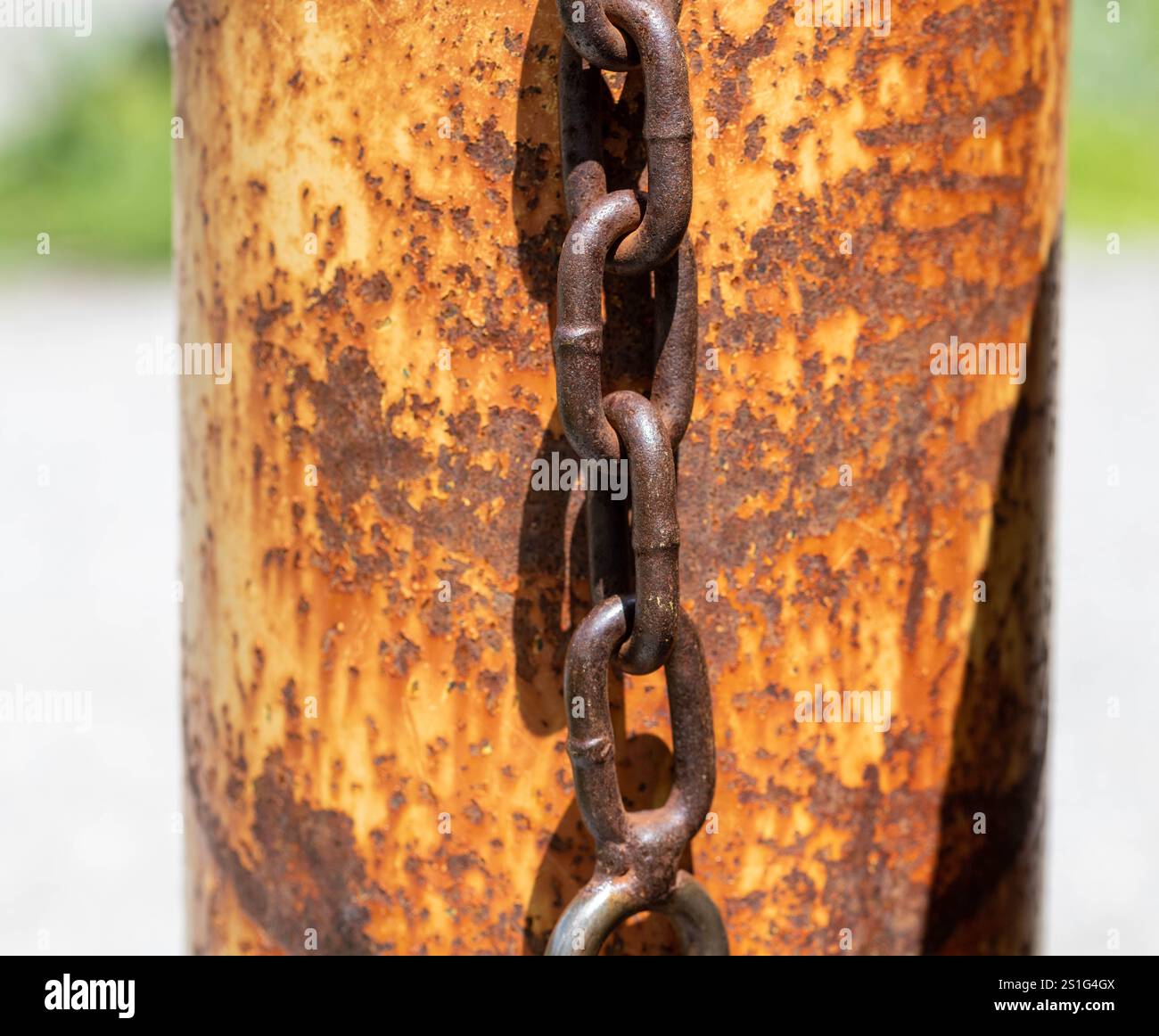 Rusty old chain and lock hanging on a rusted pole Stock Photo