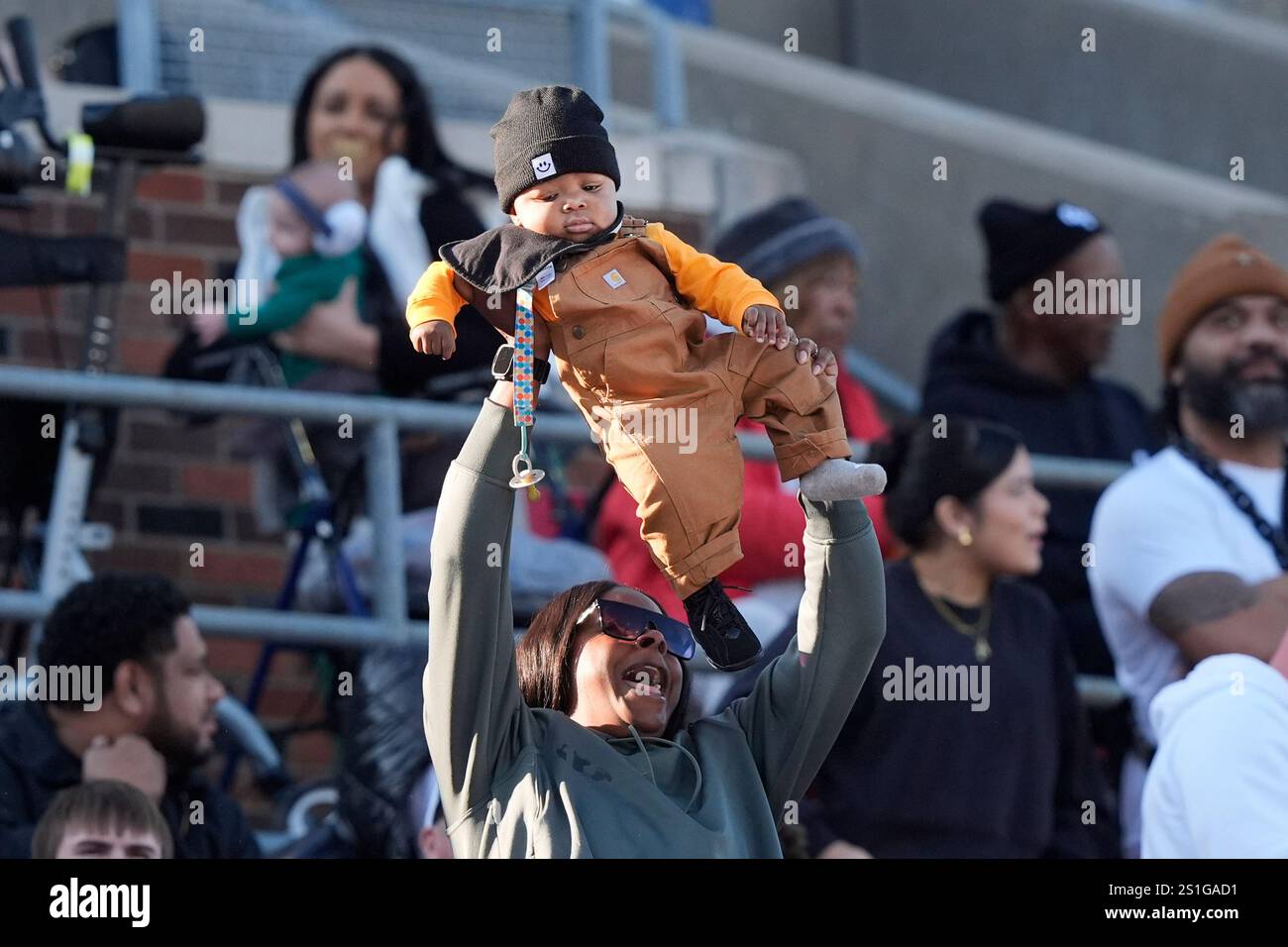 A child is held up during the first half of the First Responder Bowl