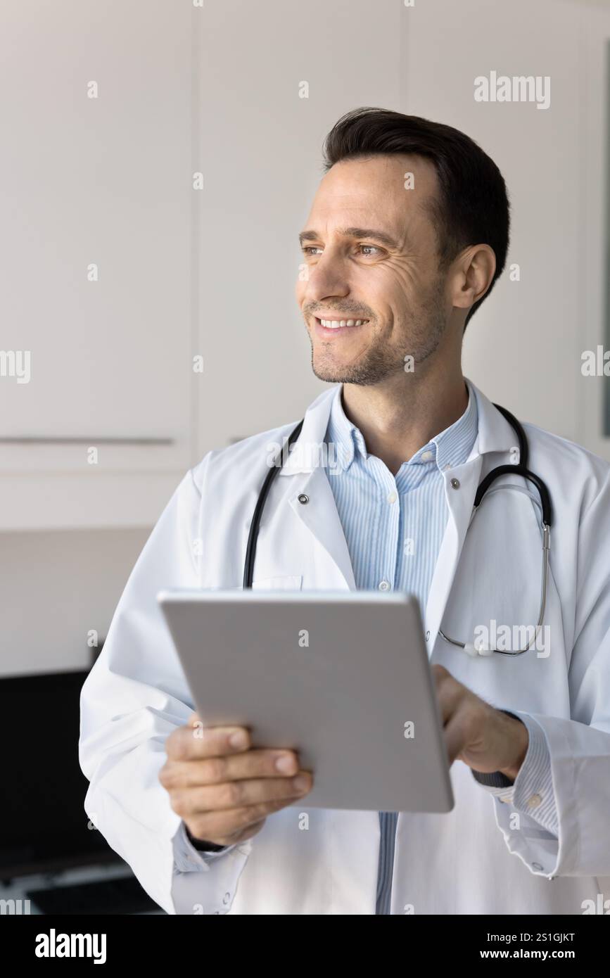 Happy general practitioner doctor using medical application on tablet Stock Photo