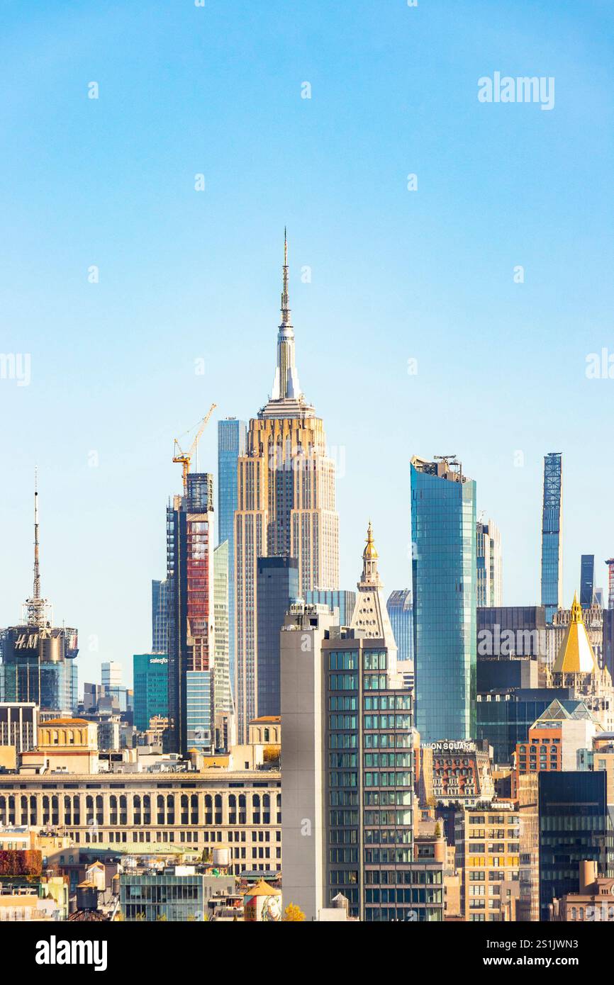 Panoramic view of the New York City skyline with iconic skyscrapers  empire state building and clear blue sky in the background Stock Photo