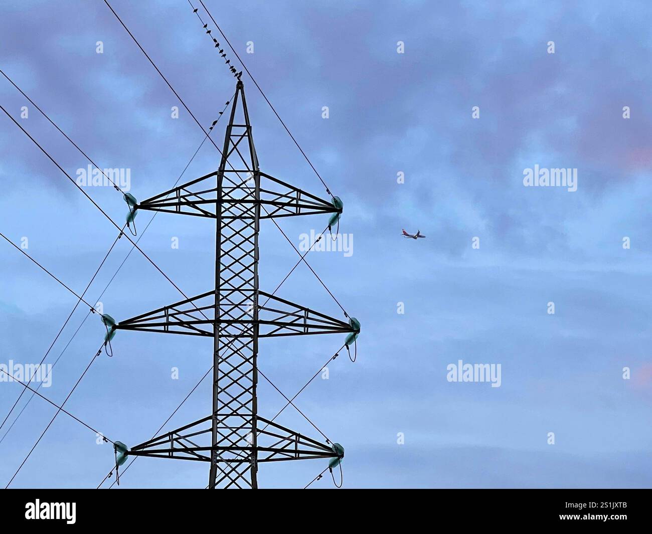 Electricity pylon and airplane flying. - Smartphone Captured Stock Image