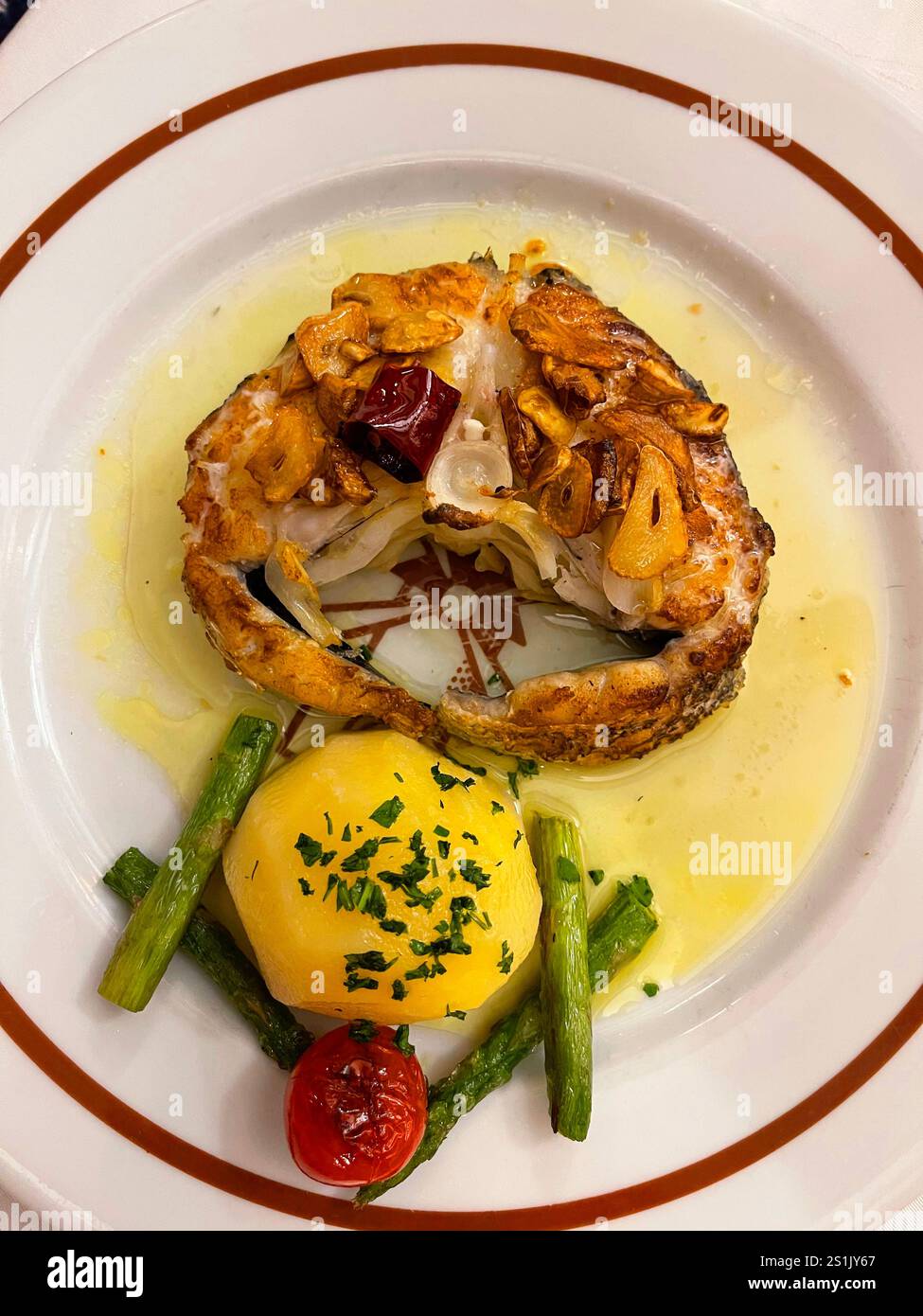 Grilled slice of hake with garlic and vegetables. Spain Stock Photo - Alamy